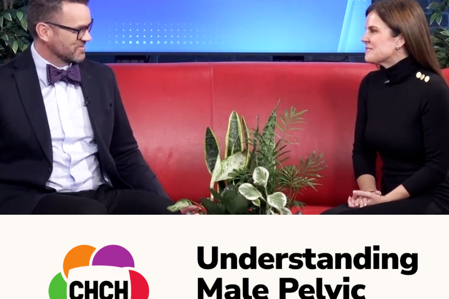Two individuals seated on a red couch during a live morning show discussing male pelvic symptoms, with plants in the foreground.